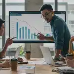 Startup founders analyzing burn rate reduction strategies on a digital dashboard.